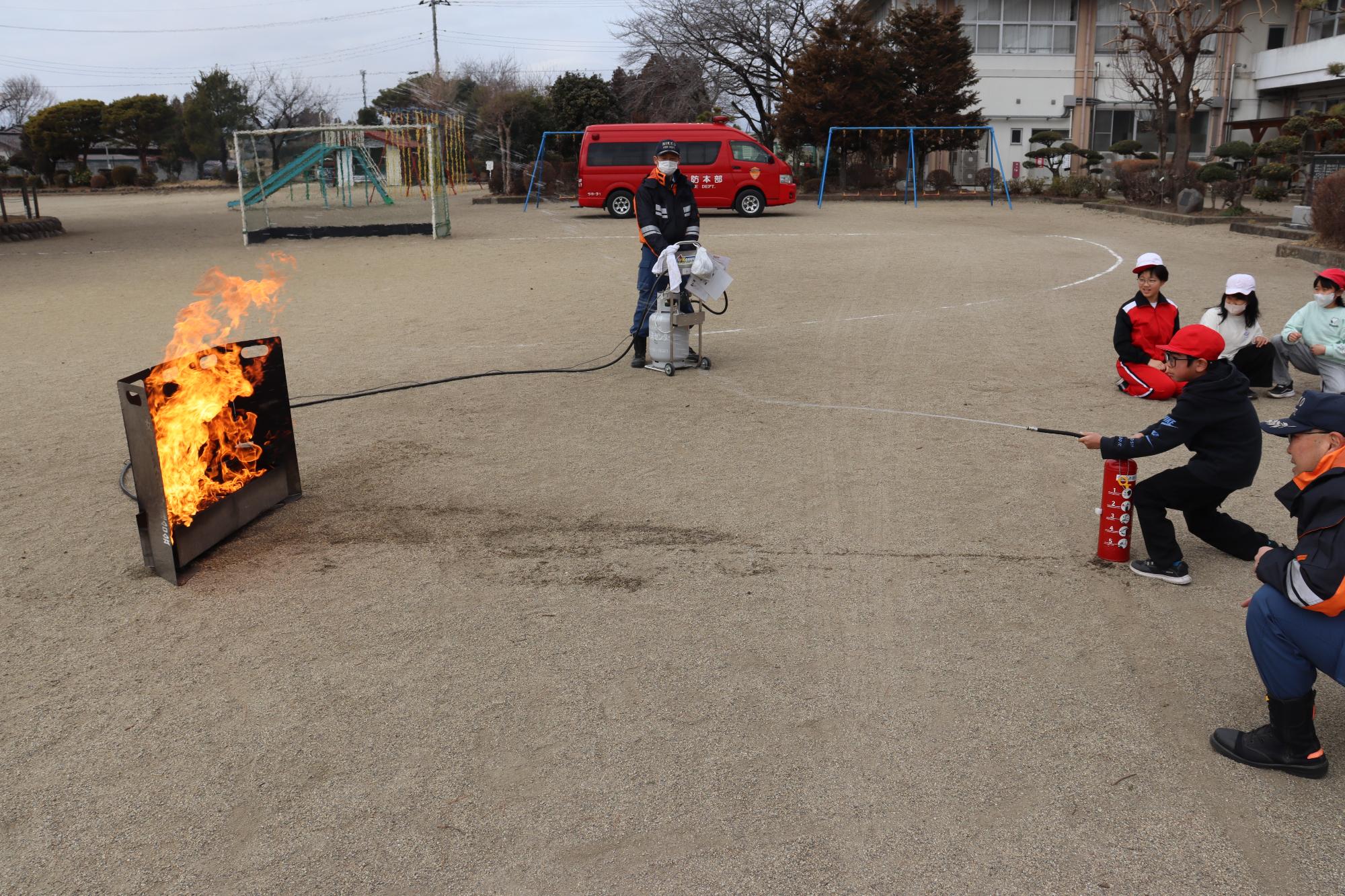消火器の取扱いを体験する児童